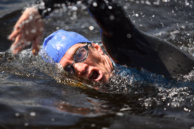 Image shows a swimmer taking a breath in the water Image shows a swimmer taking a breath in the water